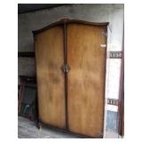 Wood wardrobe with simple embellishments on top an