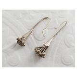 Vintage pair of silver tone earrings depicting a f