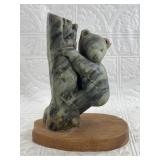 Soapstone carving of a bear climbing a tree on a w