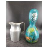 Painted gourd and a heavy aluminum pitcher