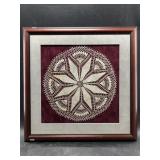 Matted and framed doily with a lovely maroon backd