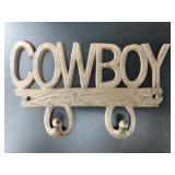 Brand new cast iron double wall hook that says "CO