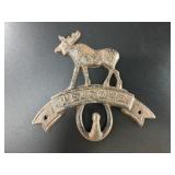 Cast iron wall hook that says "Welcome" with a moo