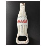Cast iron bottle opener in the shape of a Coca-Col