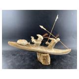 Whalebone carving of 2 hunters in their kayaks wit