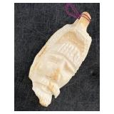 Walrus tooth pendant carved with several faces, 1.