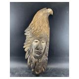 J.S.B.  Foam carving of a woman wearing an eagle's