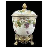 DECORATIVE GRAPE AND LEAF COVERED URN ON STAND