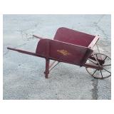 Antique wood wheelbarrow with metal spoke wheel.