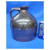Stoneware jug with slip glaze.  Small chip in