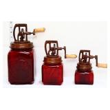 Trio of red glass butter churns