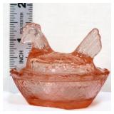 Miniature pink hen on nest
