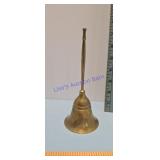 brass bell slender, elongated handle and a fluted