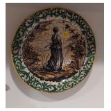 Antique decorative plate features a pastoral scene
