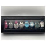 8 DESIGNER FASHION WRIST WATCHES IN DISPLAY CASE