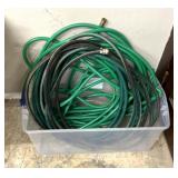 Plastic container full of garden hoses