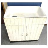 antique farmhouse utility sink with a cabinet