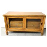 wooden media console featuring sliding glass