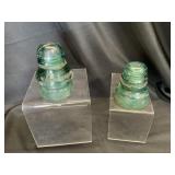 Two vintage teal-green glass insulators