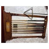 Brunswick-Balke-Collender Co. Carved Oak Combination Wall Cue Rack with An Assortment of Cues