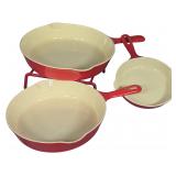 A Trio of Griswold 100th Anniversary Enameled Cast Iron Skillets with Rack