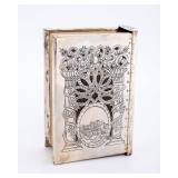 A STERLING SILVER SIDDUR BINDING BY SHUKI FREIMAN WITH ARTSCROLL SIDDUR