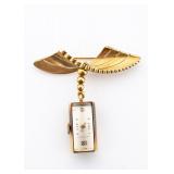 AN 18K GOLD BROOCHE WITH A DECO WATCH.