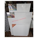 Thee stratched canvases, all still wrapped in