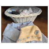 Knitted Baby Clothes in a Wicker Doll Bed