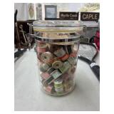 sewing thread spools In glass canister (garage