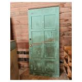 Older solid wood door, left of the garage