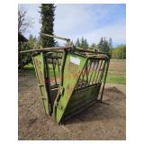 Powder River squeeze chute, tractor on site to