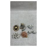 collection of vintage brooches and earrings.