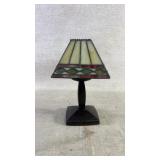 A mini lamp with a Tiffany style lamp shade