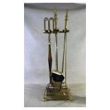 A five-piece polished brass fireplace tool set.