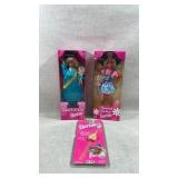 collection of Barbie dolls and a watch, still in