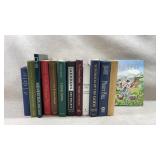 varied row of 13 hardcover books and novels