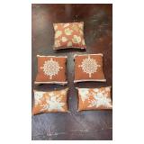 set of five rust-orange decorative throw pillows