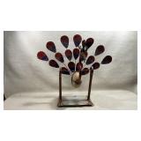 handcrafted metal and stone rocking peacock