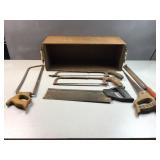 Various metal hand saws and wooden box