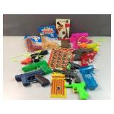 Lot of water guns, ring caps, guns book and toy