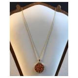 Gold toned necklace with orange and amber pendant