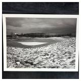 Snow-Dusted Golf Green with Clubhouse in Distance