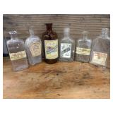 6 VINTAGE BOTTLES WITH PRINTED LABELS