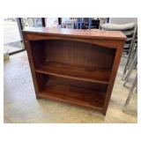 Low, two-shelf wooden bookcase or hutch with a