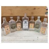 7 VINTAGE BOTTLES WITH PRINTED LABELS