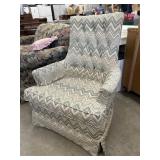 Vintage upholstered, high-back armchair featuring