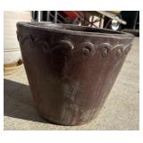 A brown conuco clay pot with textured wave design.
