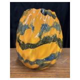 A bright orange hand-blown glass vase features