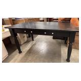 Rectangular black dining table with drawers.